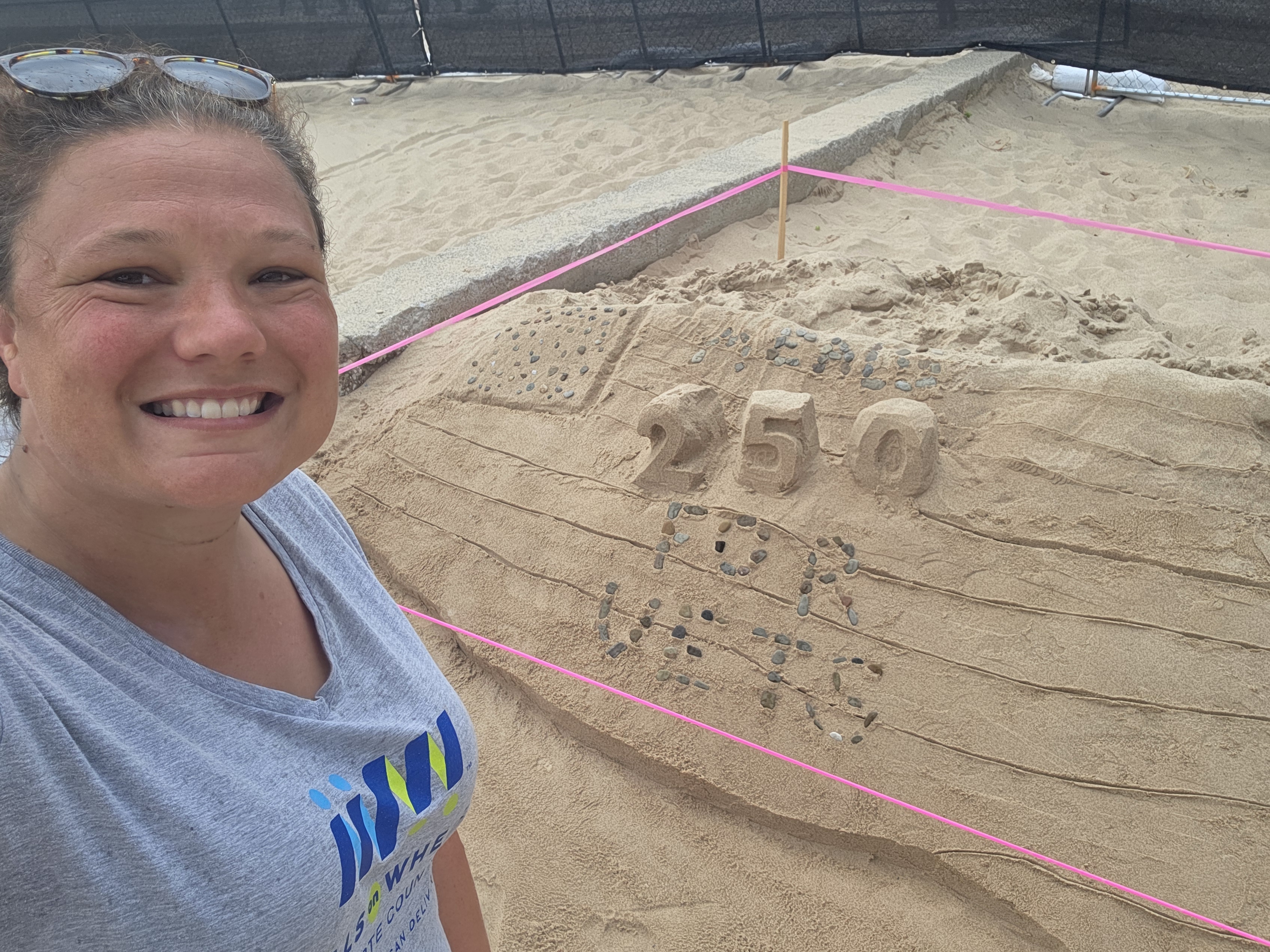 Staff member with the completed sand sculpture