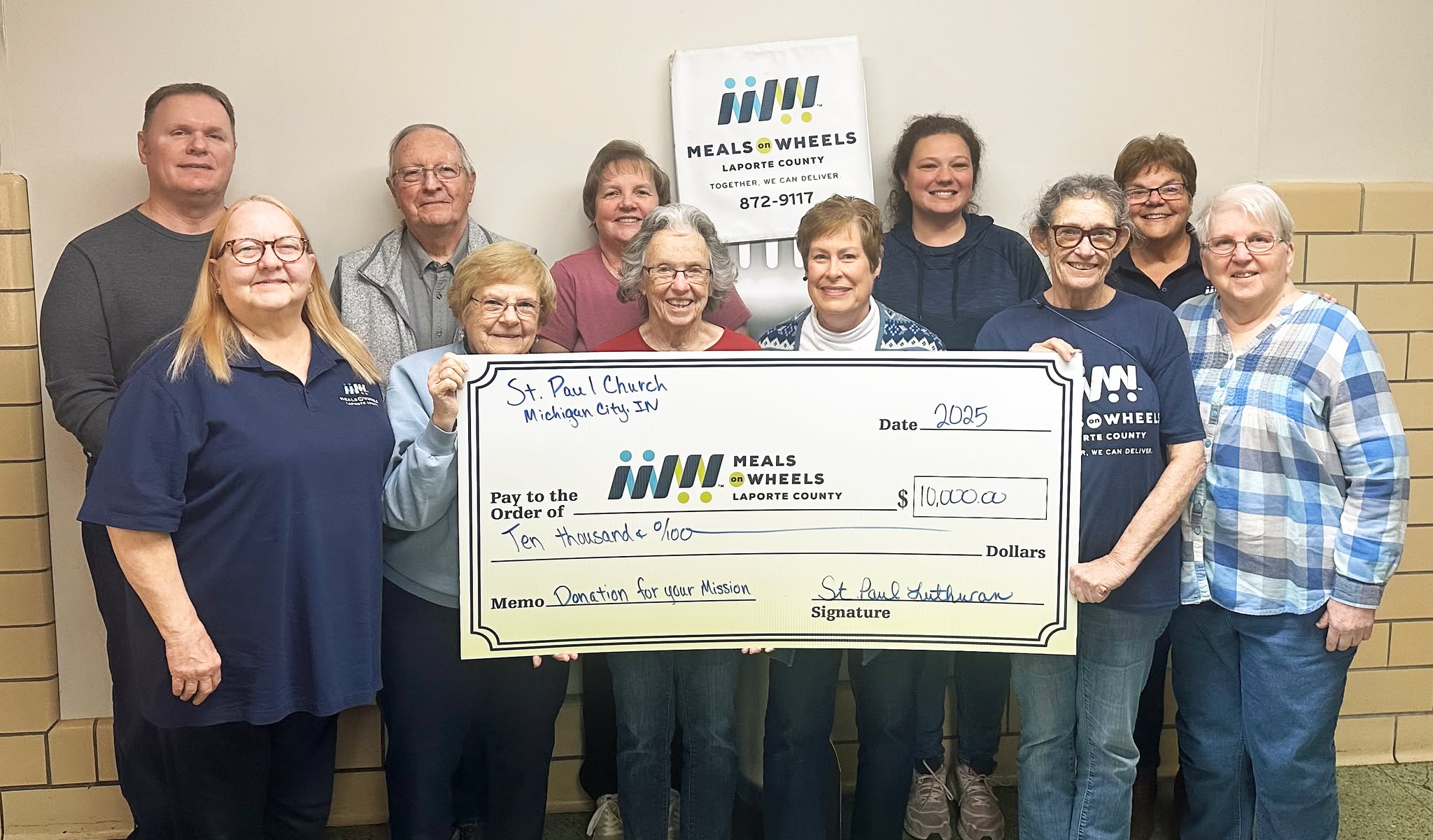 Community members holding a $10,000 donation check from St. Paul Lutheran Church