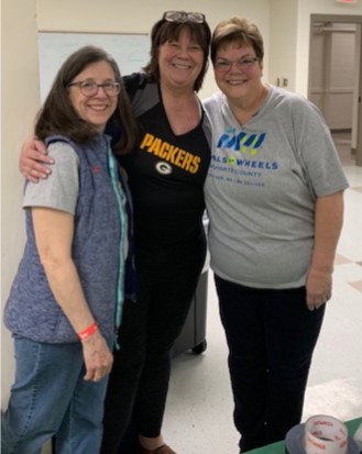 Volunteers socializing at a Meals on Wheels trivia fundraiser